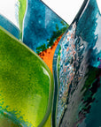 Details of fused glass fold form vase, with bright greens and textural detailing. 