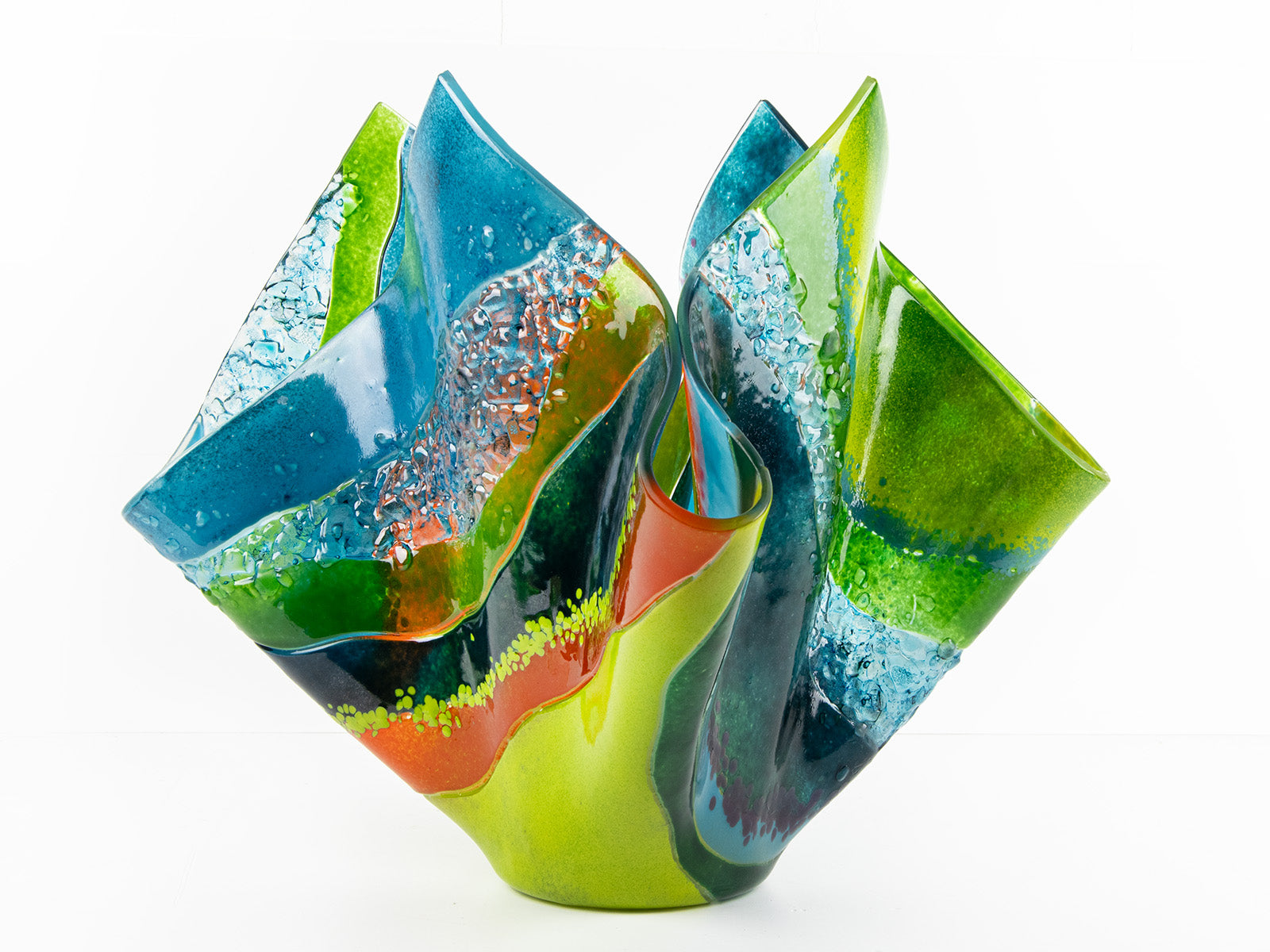 Main image of fused glass fold form vase, with bright greens and textural detailing. 
