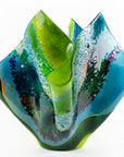 Fourth image of fused glass fold form vase, with bright greens and textural detailing. 