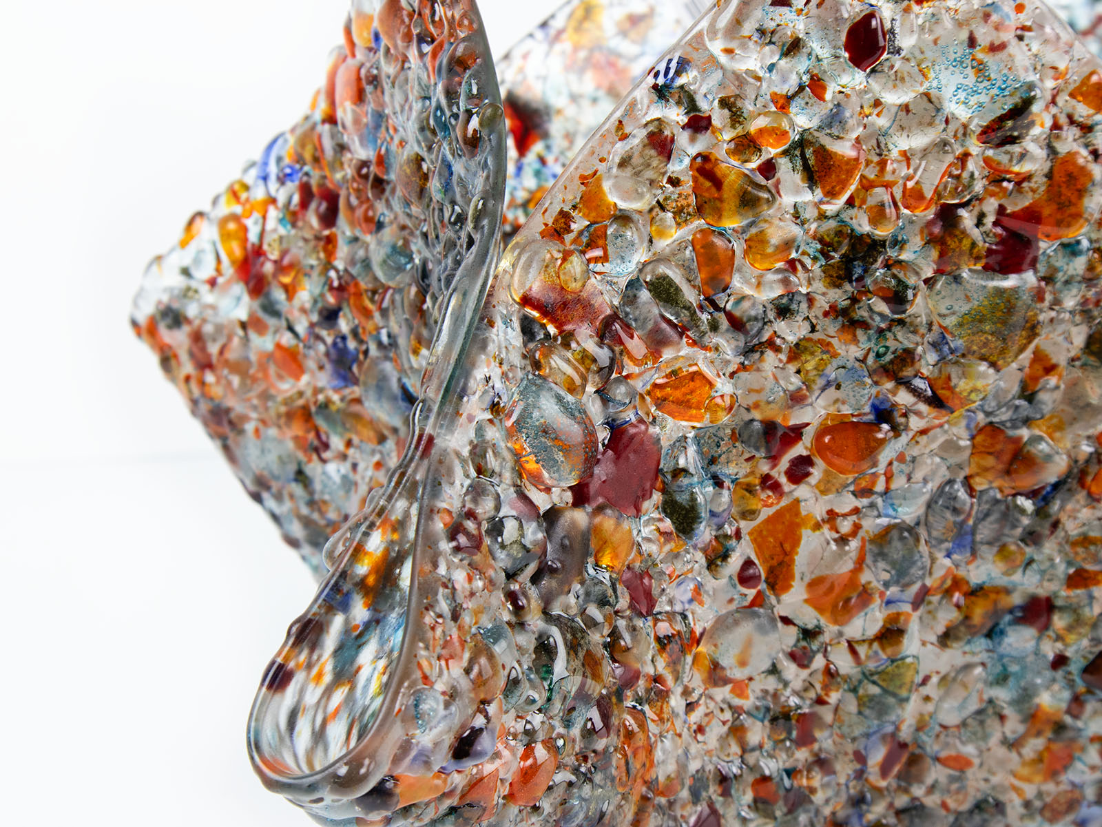 details of a fold form fused glass vase, made with recycled crushed glass in warm colours to create a stunning piece of art.