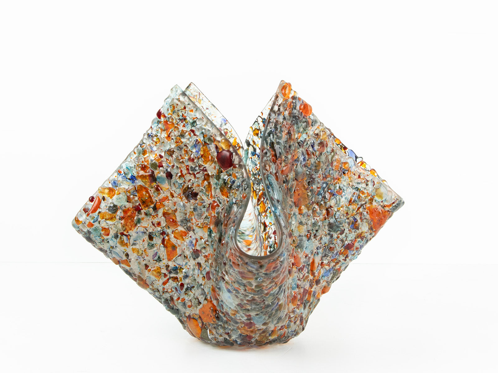 A fold form fused glass vase, made with recycled crushed glass in warm colours to create a stunning piece of art.