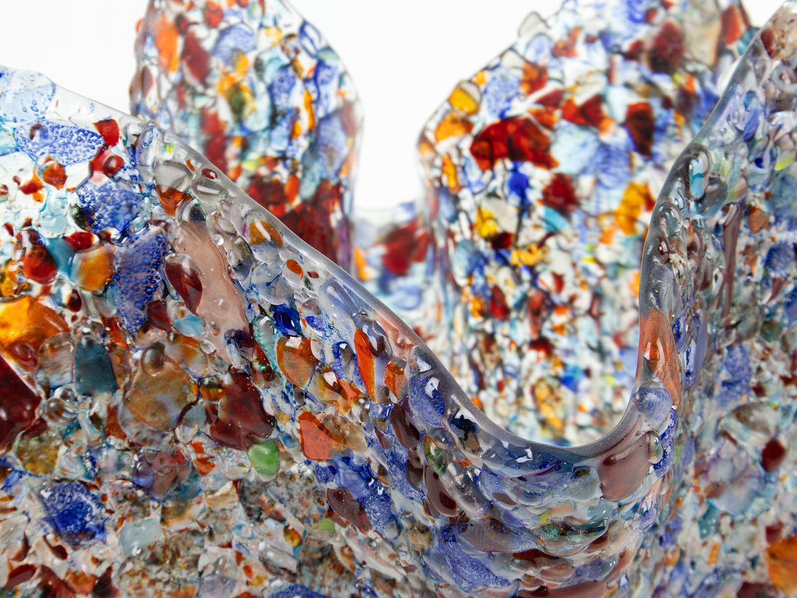 Textured detailing of a fold form fused glass vase, handmade using recycled glass in vibrant colours. 
