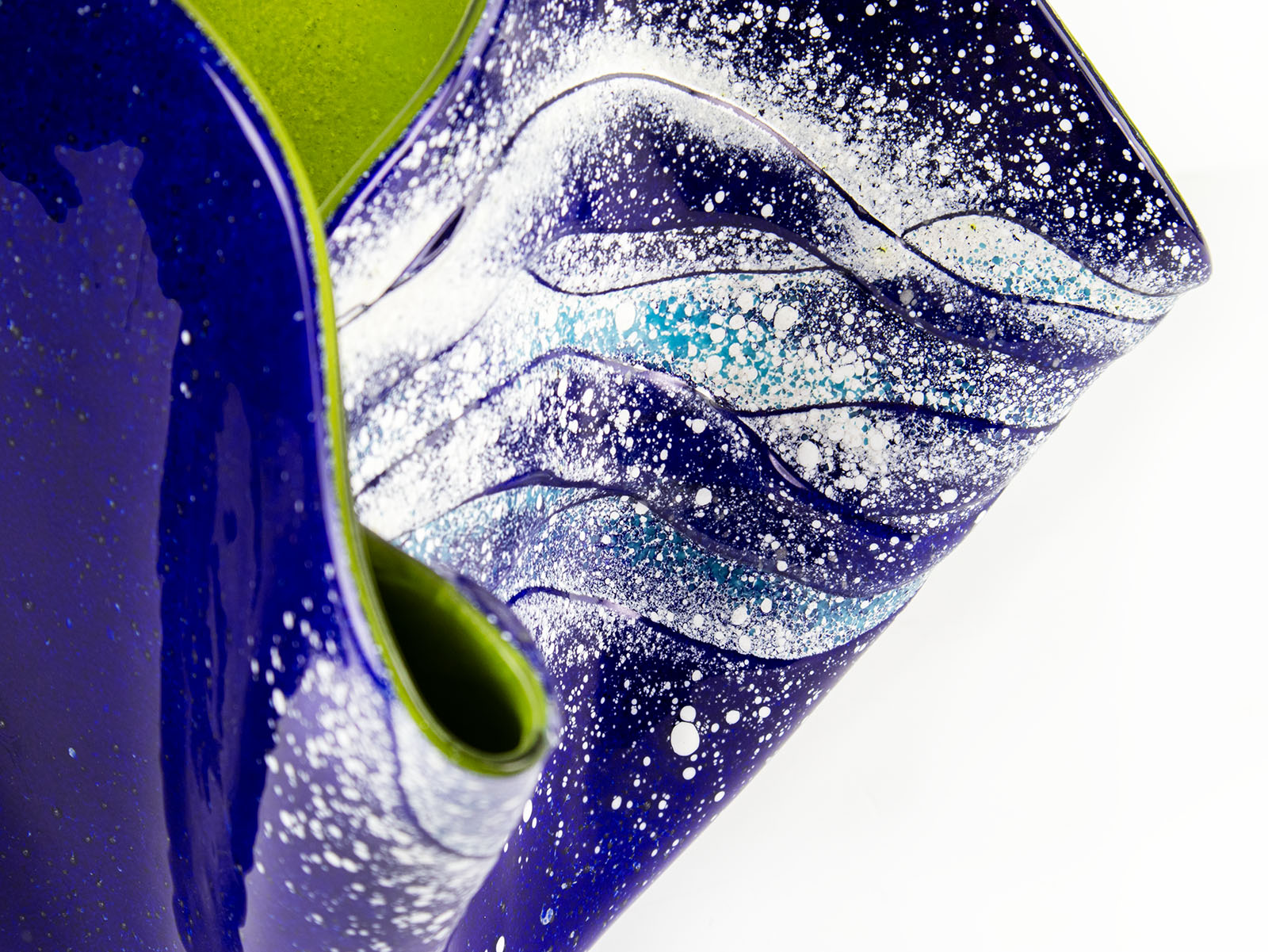 Close up details of an opaque ocean inspired fused glass fold form vase with bright coastal colours and texture. 