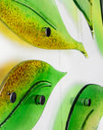 Details of fused glass wall art display featuring individual spring leaves in vibrant colours. 
