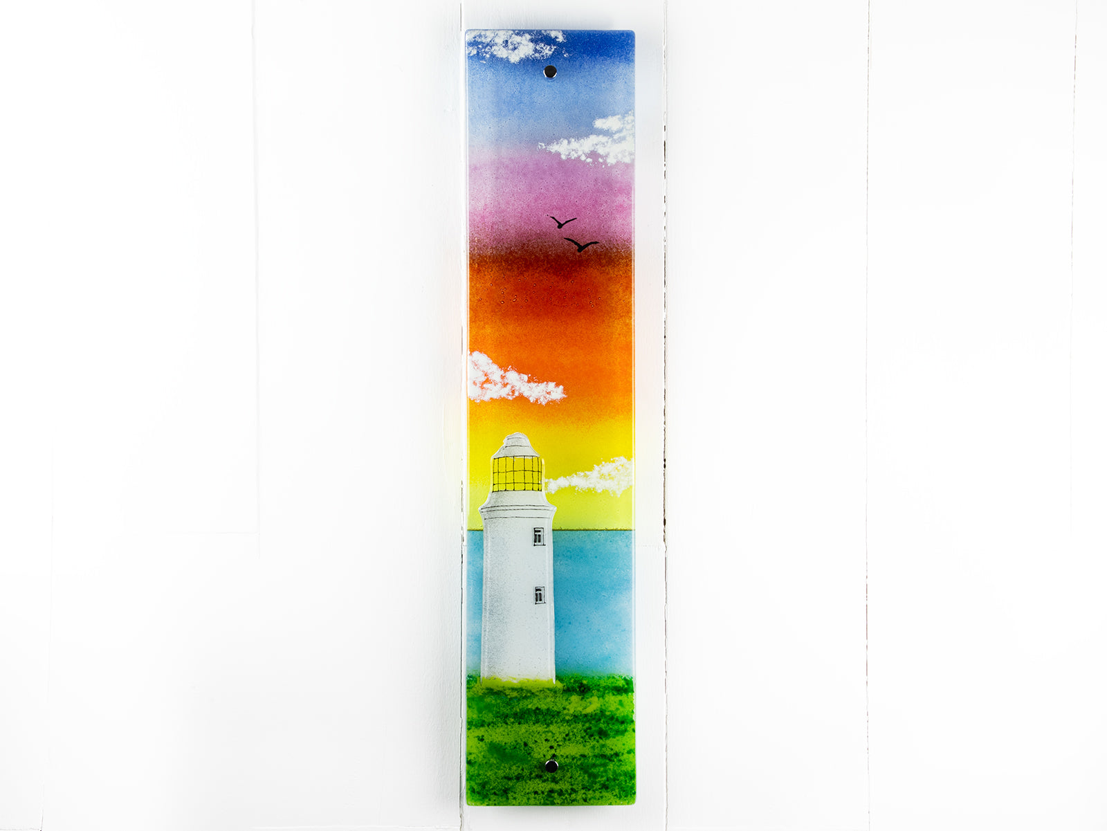 Fused glass wall panel, featuring a Cornish lighthouse design with a sunset sky. 