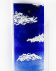 Details of a fused glass wall panel featuring a Cornish lighthouse sat against a coastal blue design.  