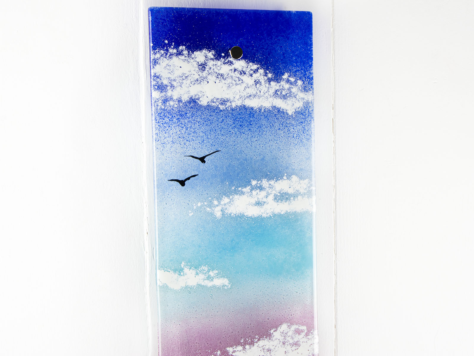 Details of fused glass wall panel featuring a Cornish tin mine, with a vibrant sunset sky and soaring gulls. 