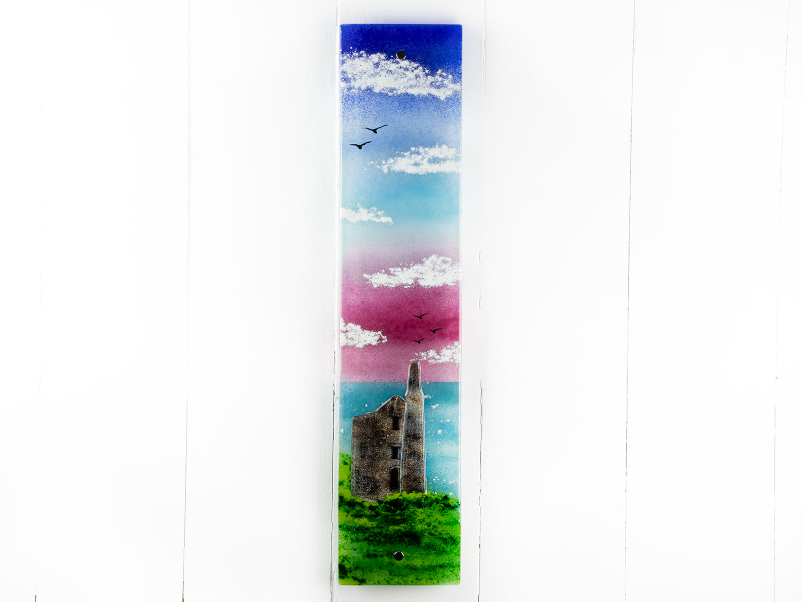 Fused glass wall panel featuring a Cornish tin mine, with a vibrant sunset sky and soaring gulls. 