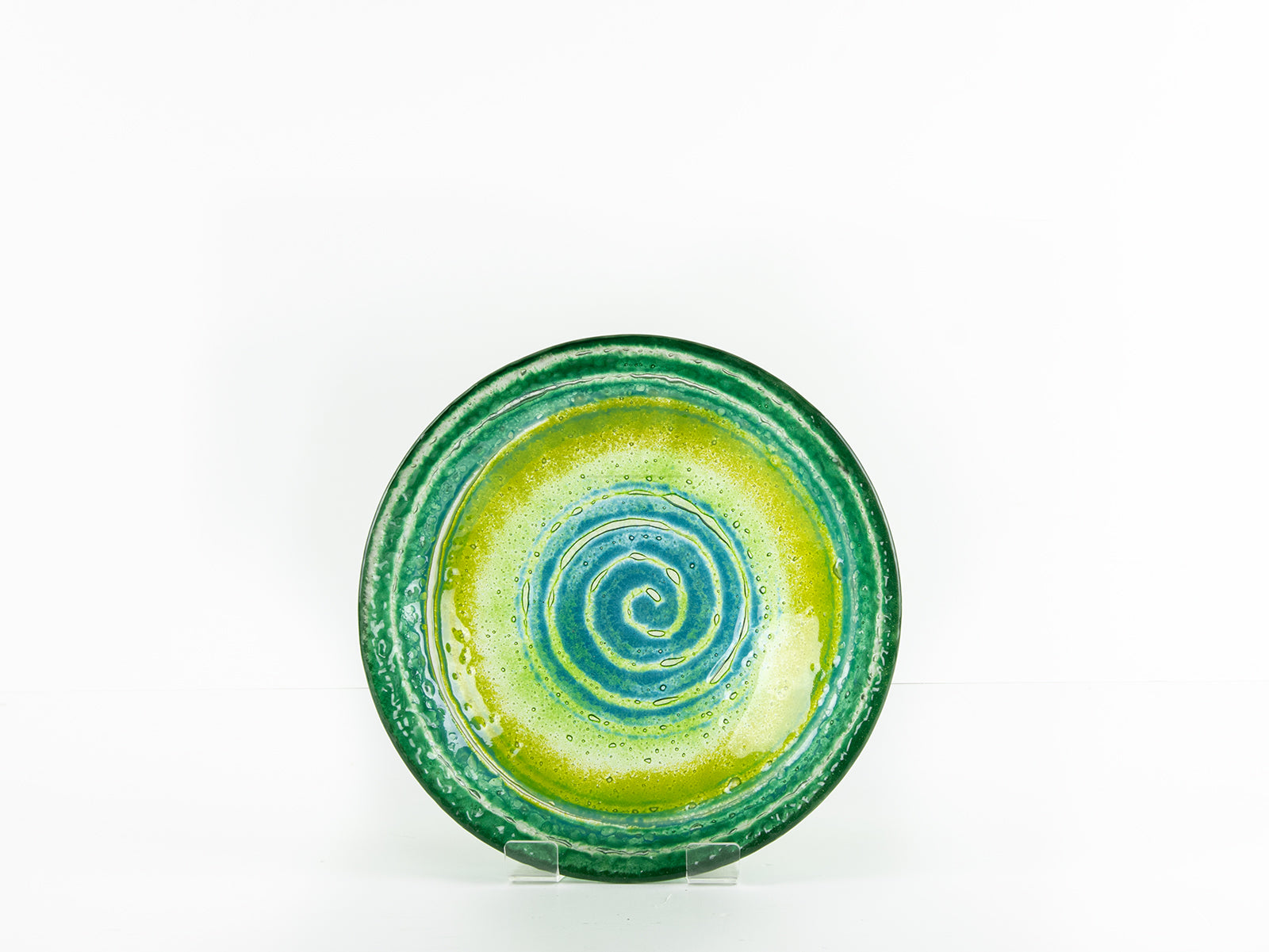 Fused glass round dish featuring bright sea greens and swirling aqua detailing. 