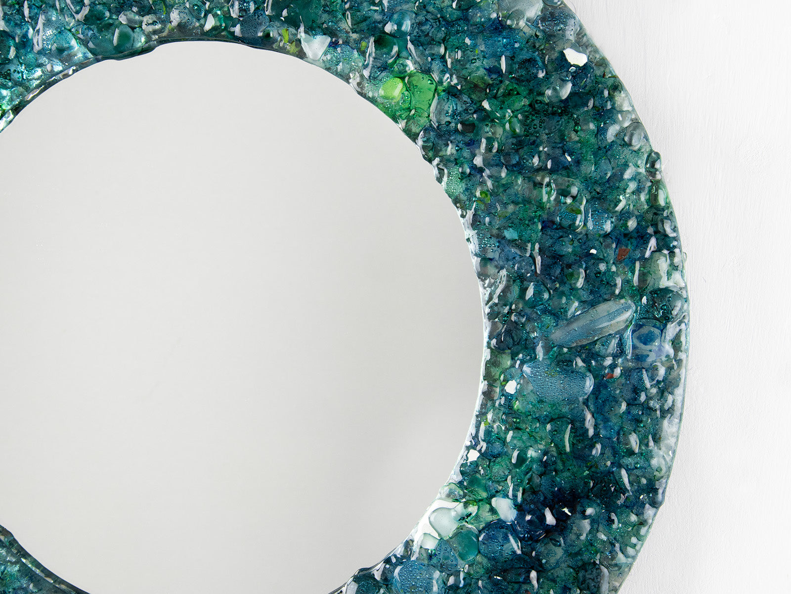 Details of fused glass round mirror, made from recycled glass in coastal greens