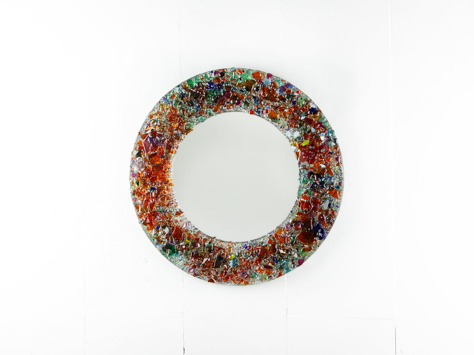 Fused glass round mirror, made from recycled glass in sunset orange and reds