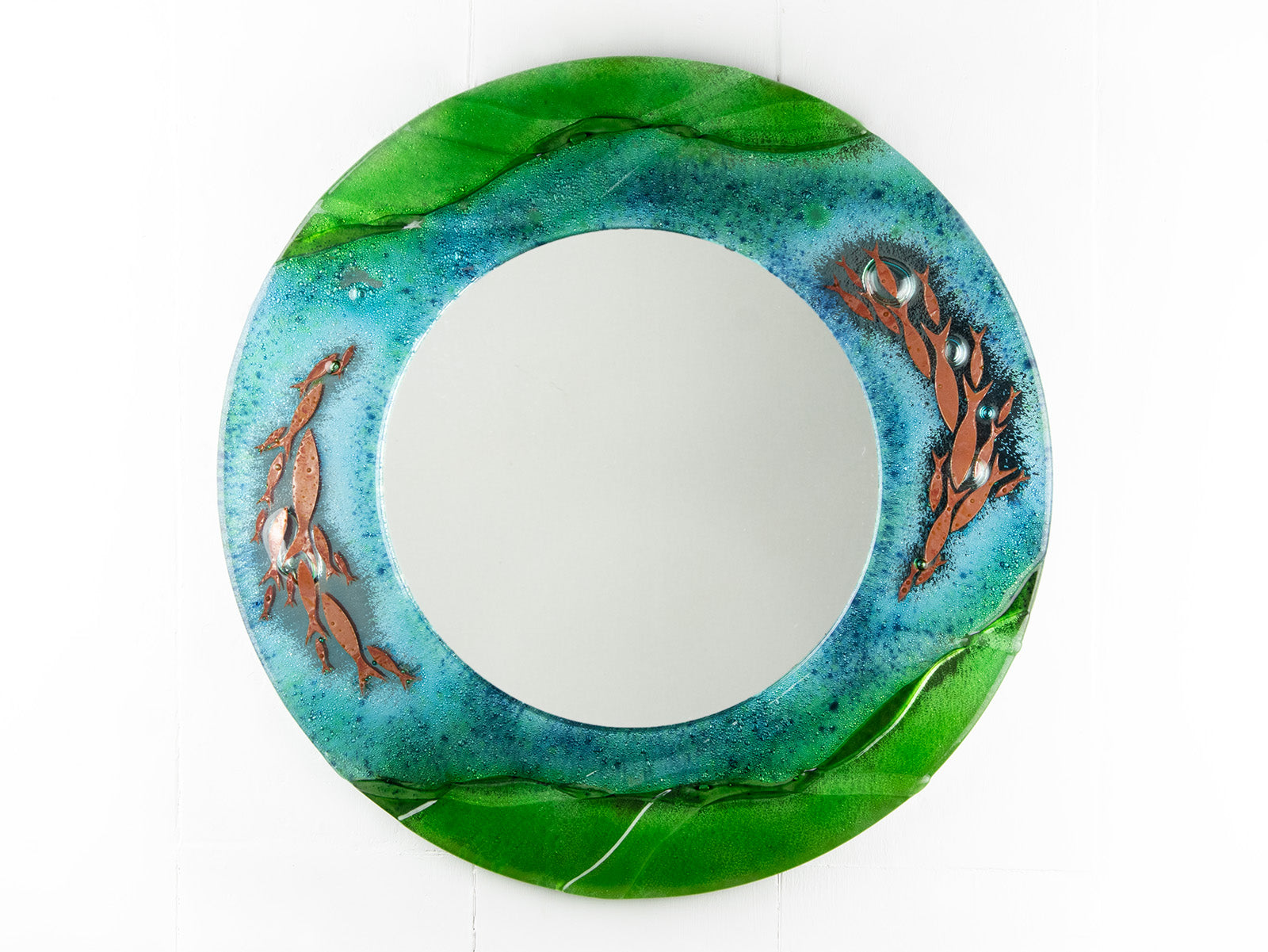 Fused glass round mirror, featuring coastal design in sea greens and blues with copper fish. 