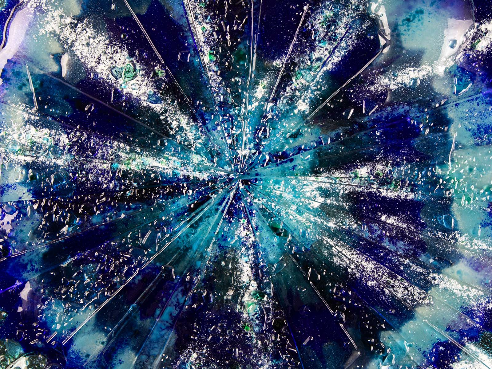 Close up details of fused glass round panel, with sea blues and lots of texture.