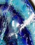 Close up of a big bubble on fused glass round panel with sea blues and textural detail. 
