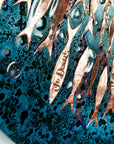 Etched signature on a copper fish on an ocean inspired fused glass wall art design.
