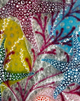 Close up of starfish design in bright pinks and sea blues, inspired by he ocean reefs on a fused glass piece of wall art.