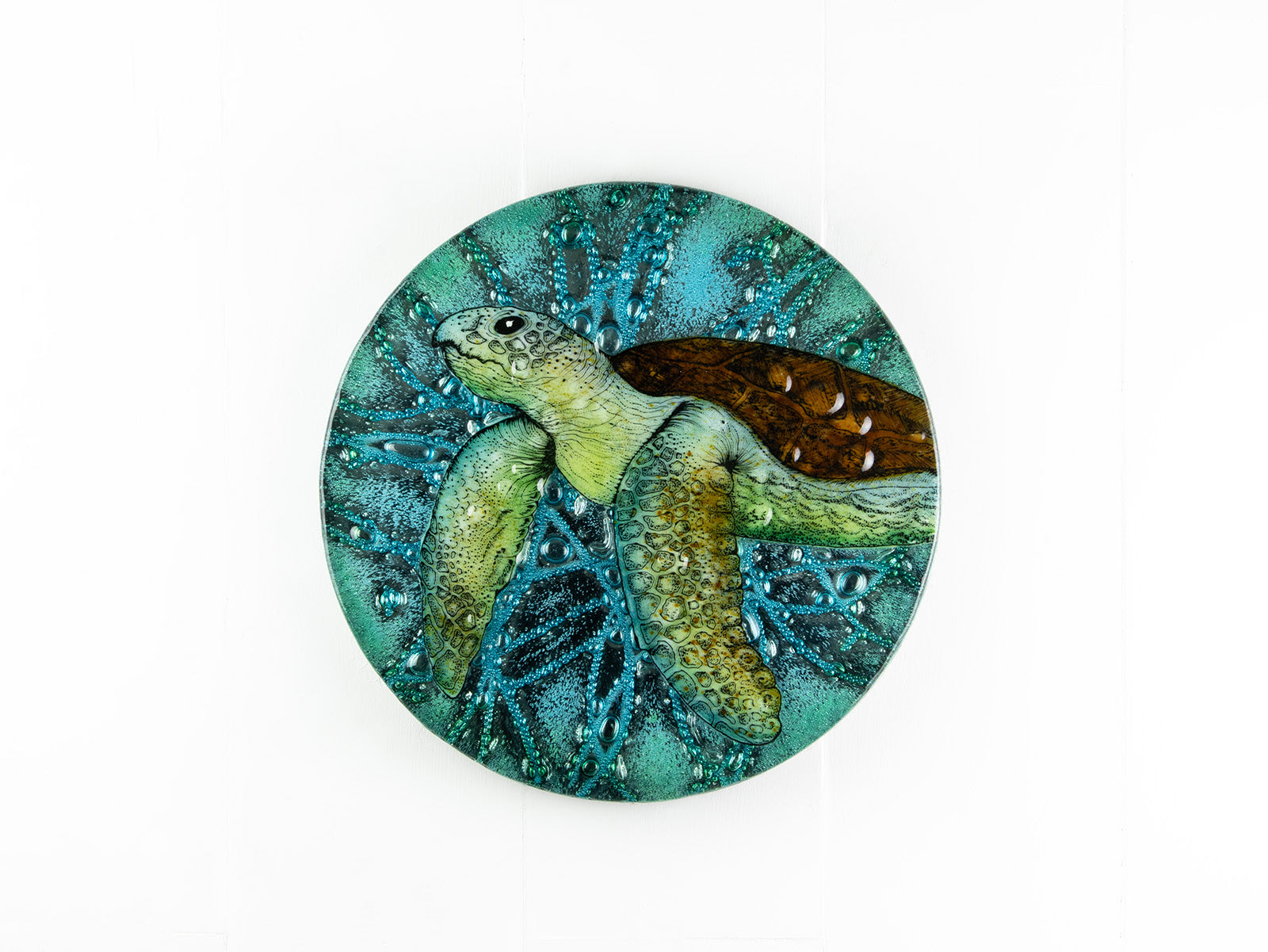Fused glass round panel with hand-painted sea turtle and aqua bubbled background. An ocean inspired piece of wall art. 