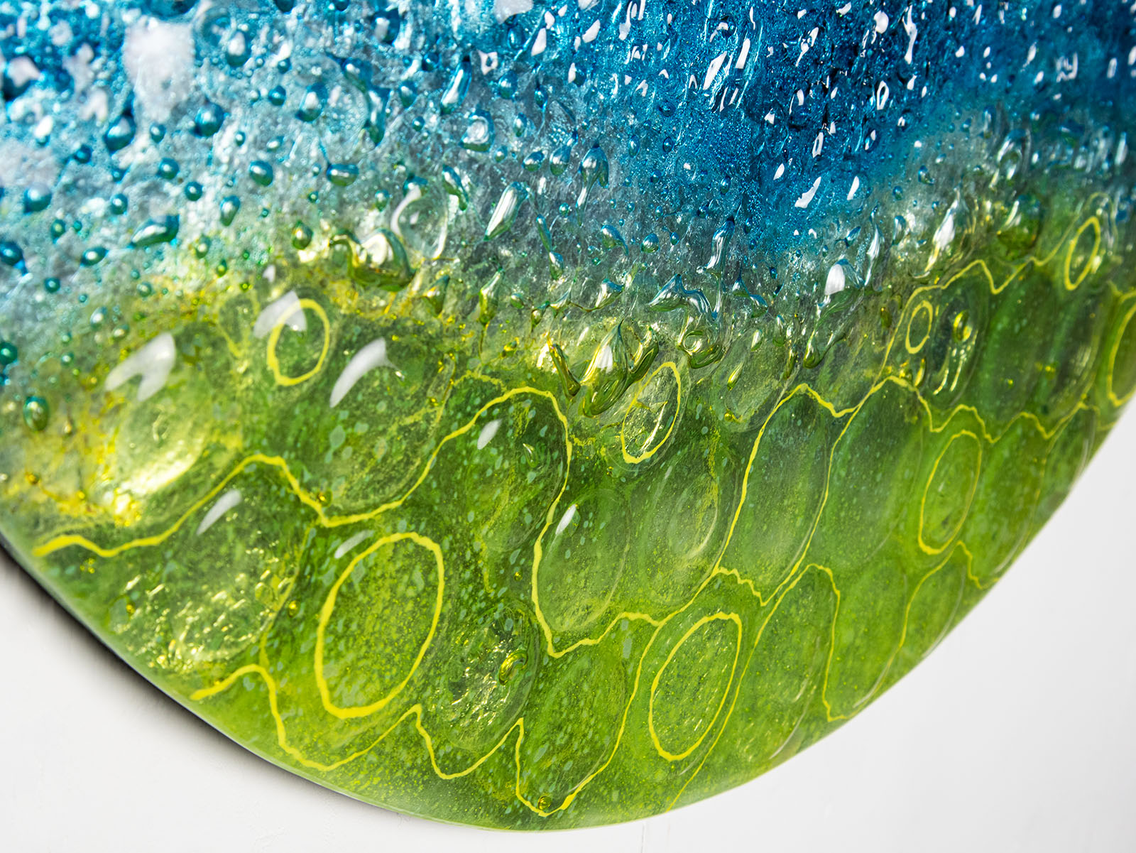 Fused glass abstract round panel details with coastal yellows.