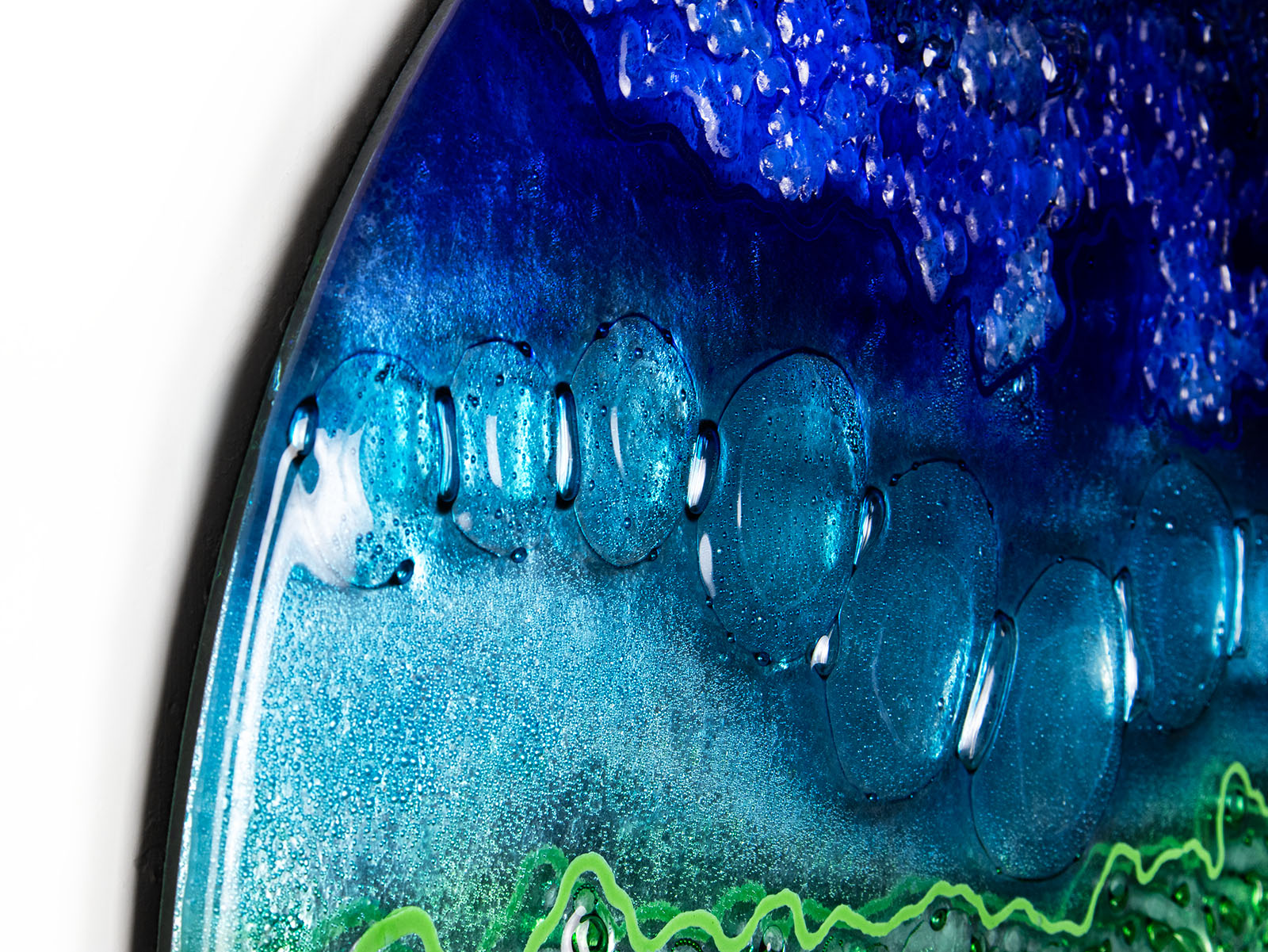 Close up of round panel with ocean blue hues and textural detail.