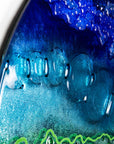 Close up of round panel with ocean blue hues and textural detail.