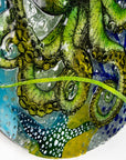 Fused glass round wall panel with a green octopus design, hand-painted with organic, textured detail. A ocean reef inspired piece of wall art. 