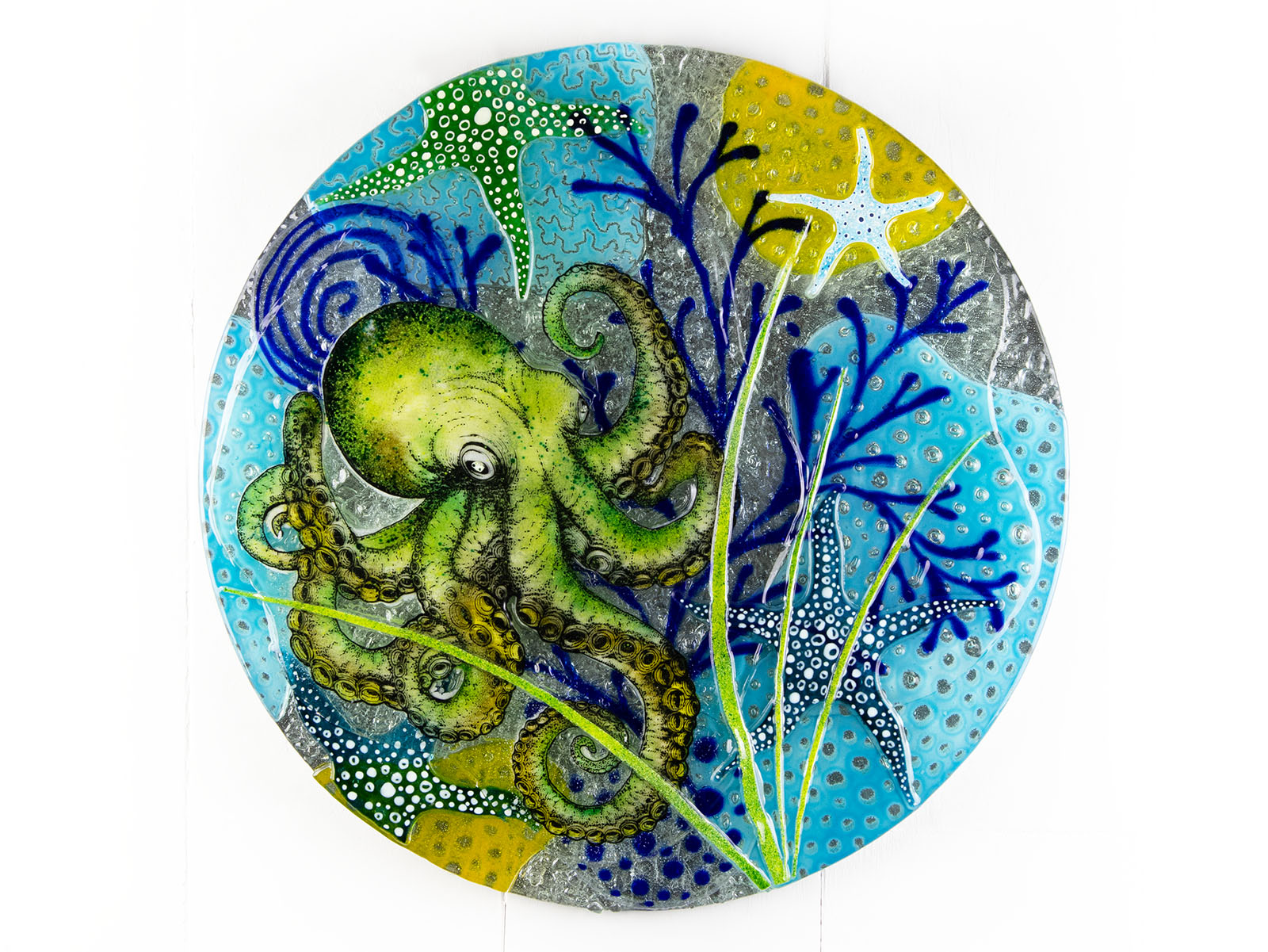 Fused glass round wall panel with a green octopus design, hand-painted with organic, textured detail. A ocean reef inspired piece of wall art. 