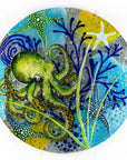 Fused glass round wall panel with a green octopus design, hand-painted with organic, textured detail. A ocean reef inspired piece of wall art. 