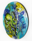 Fused glass round wall panel with a green octopus design, hand-painted with organic, textured detail. A ocean reef inspired piece of wall art. 