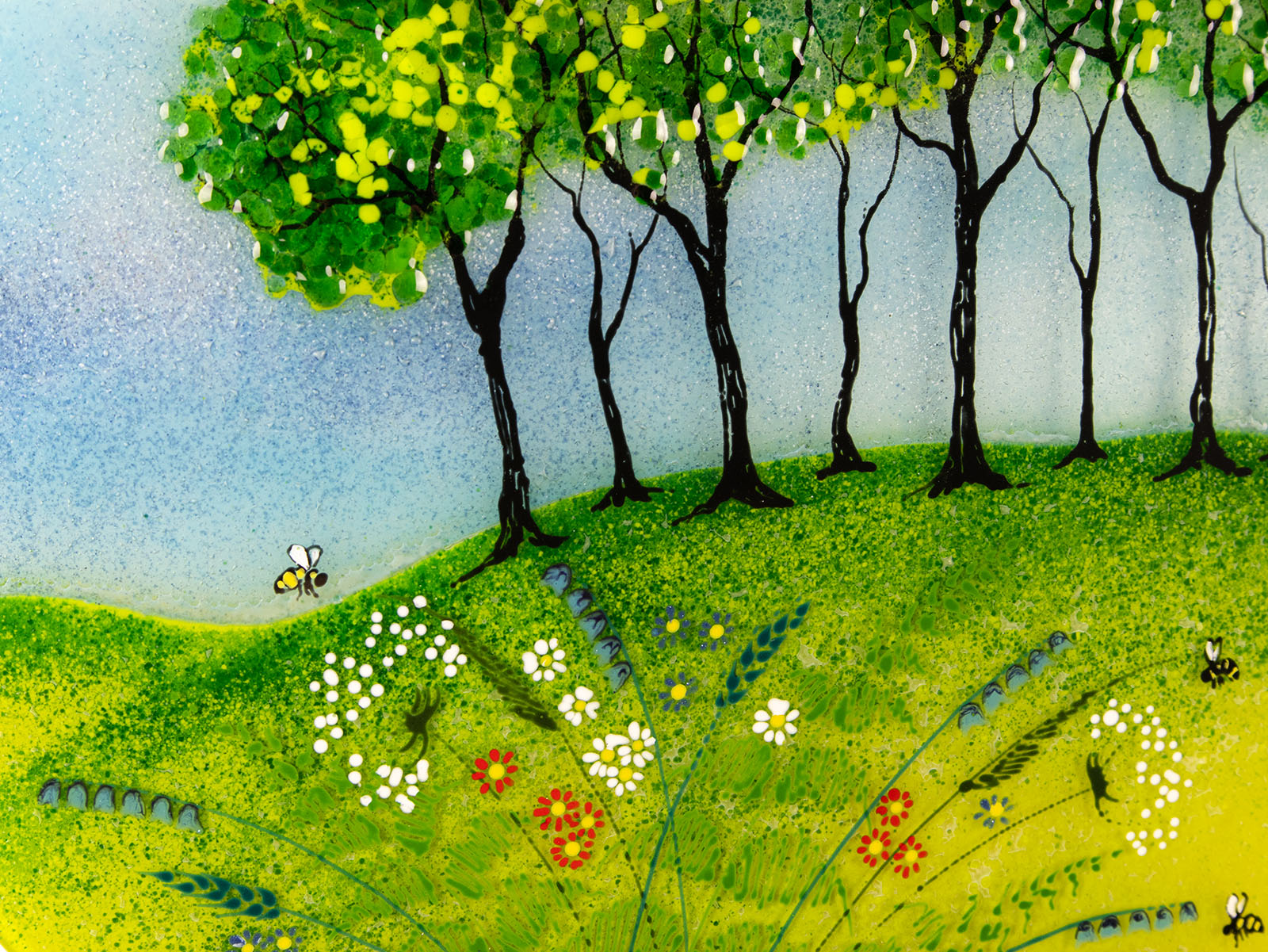 Close up of fused glass round panel, inspired by the Nearly Home Trees in Devon, designed in bright summer greens. Design includes hand-painted bees and flowers. 