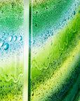 Close up of a fused glass triptych with emerald green colours in an organic, ocean inspired design. 