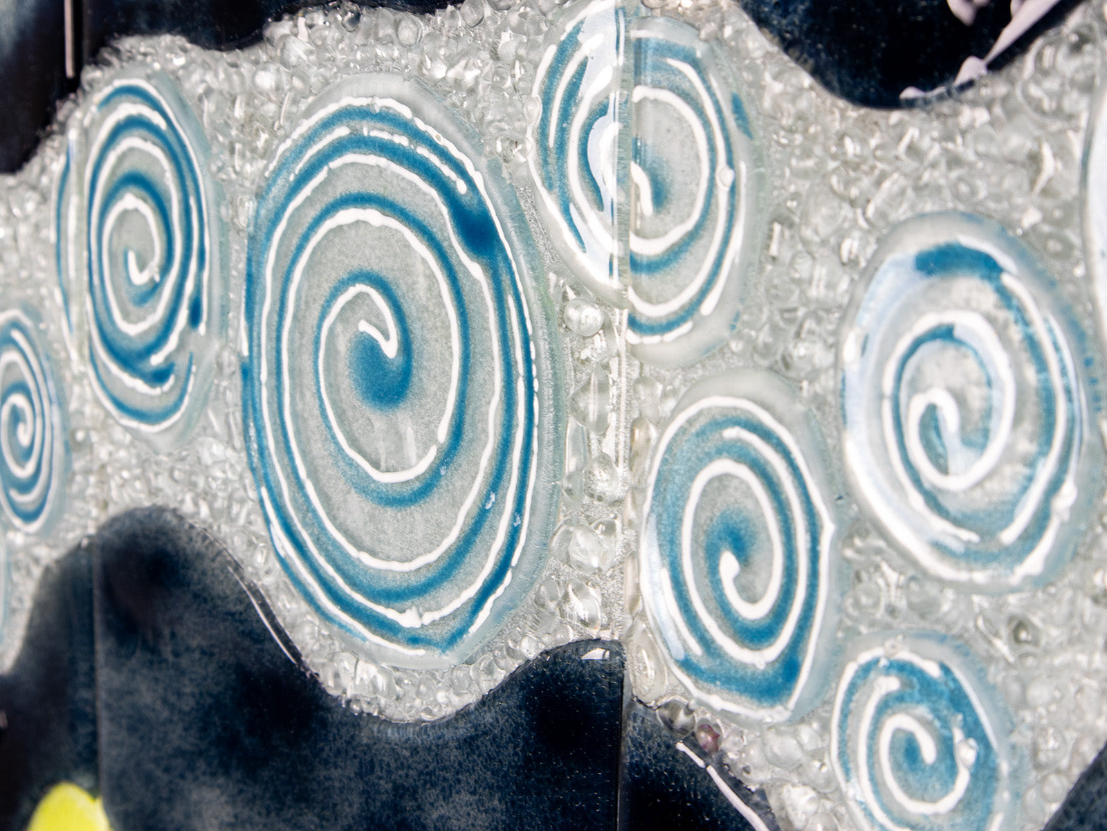 Details of a fused glass triptych with swirling detailing, capturing a gorgeous ocean design. 