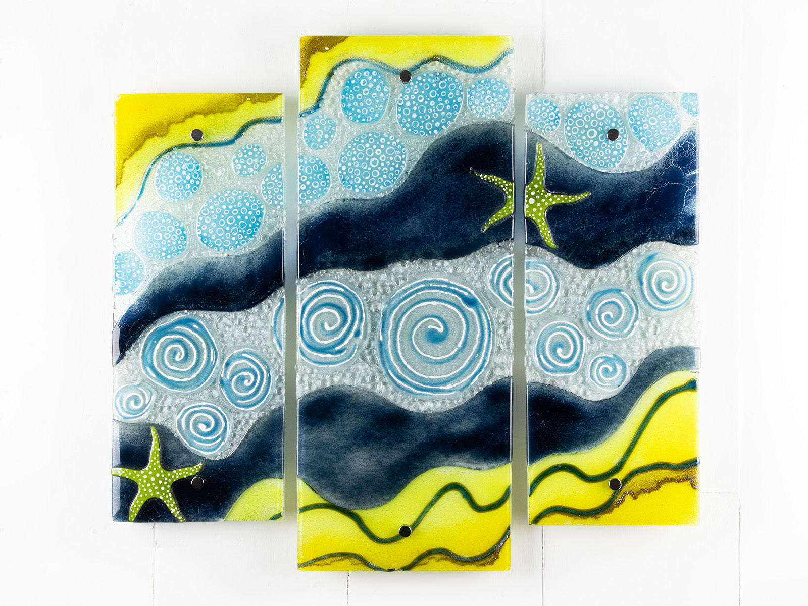 Fused glass triptych with swirling detailing and starfish, capturing a gorgeous ocean design. 