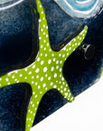 Close up of fused glass triptych inspired by the ocean with starfish detailing and coastal colours. 