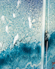 Textured detailing of fused glass triptych depicting a beach scene with blue water.