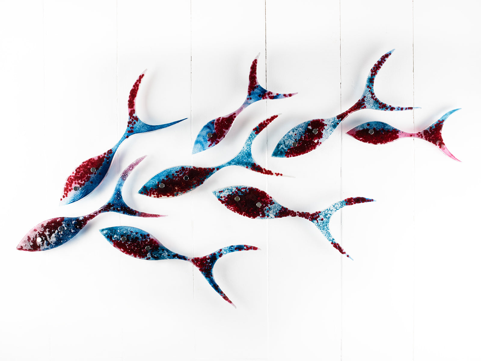 Fused glass shoal of fish in a soft blue and textured burgundy colour-way.