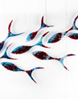 Fused glass shoal of fish in a soft blue and textured burgundy colour-way.