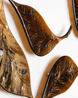 Close up of fused glass leaf wall art installation, designed in organic brown hues with shimmering gold detail. 