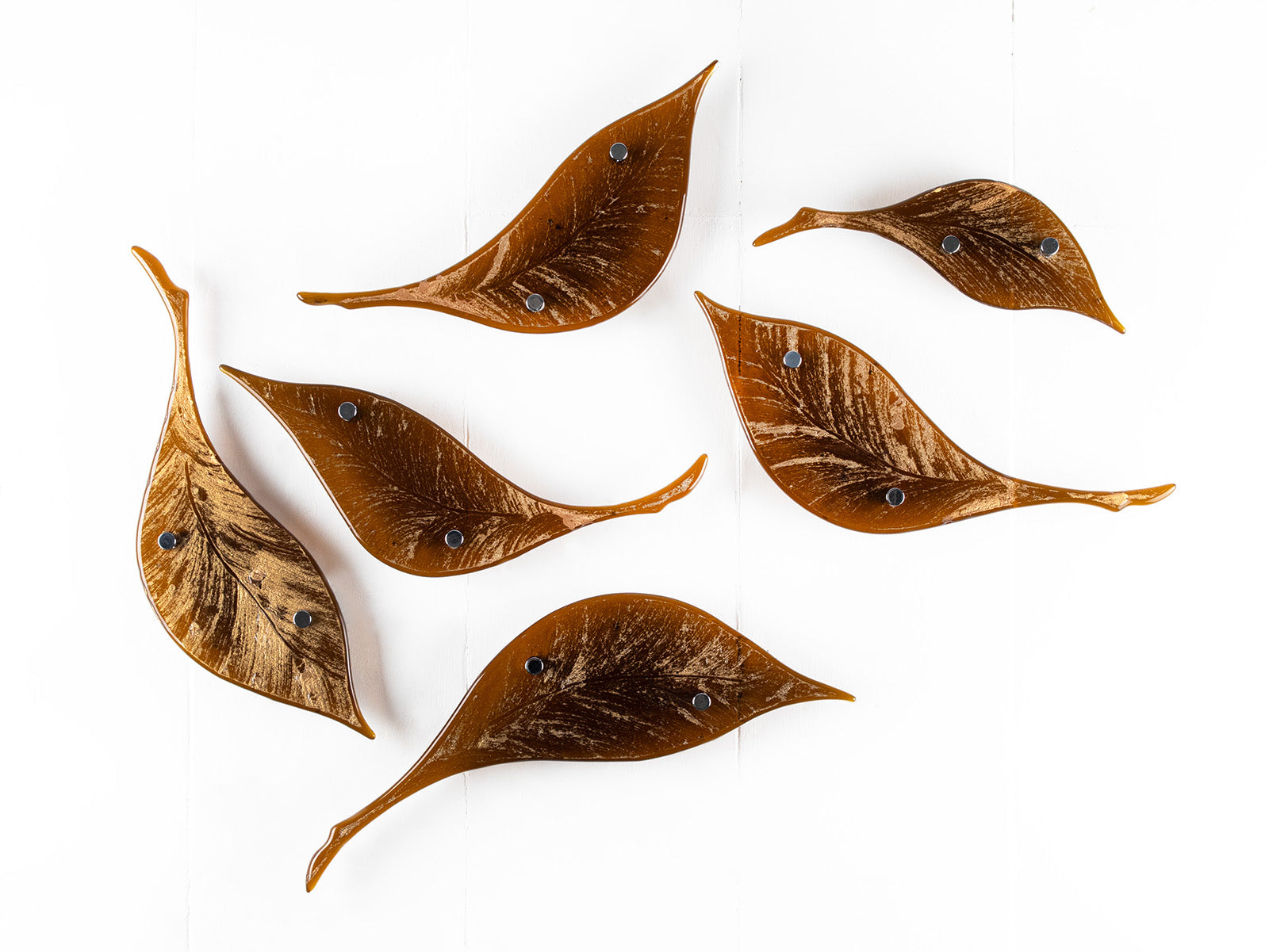 Fused glass leaf wall art installation, designed in organic brown hues with shimmering gold detail. 