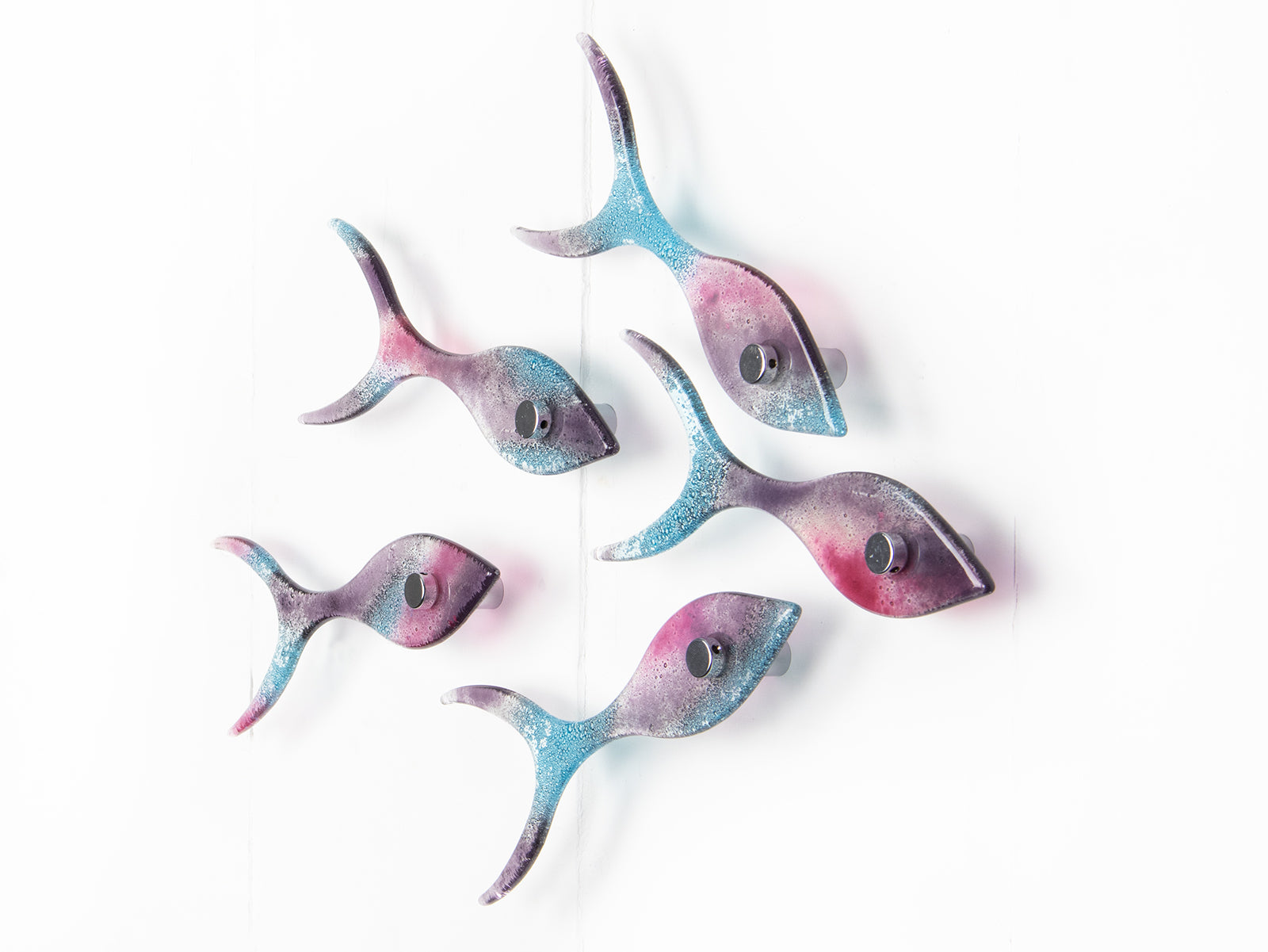 Fused glass shoal of fish on a wall, handmade in bright pinks and coastal blues.