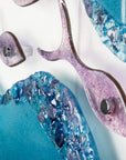 Close up of glass fish on a fused glass wall art display with shoal of fish and coastal blue colours. 