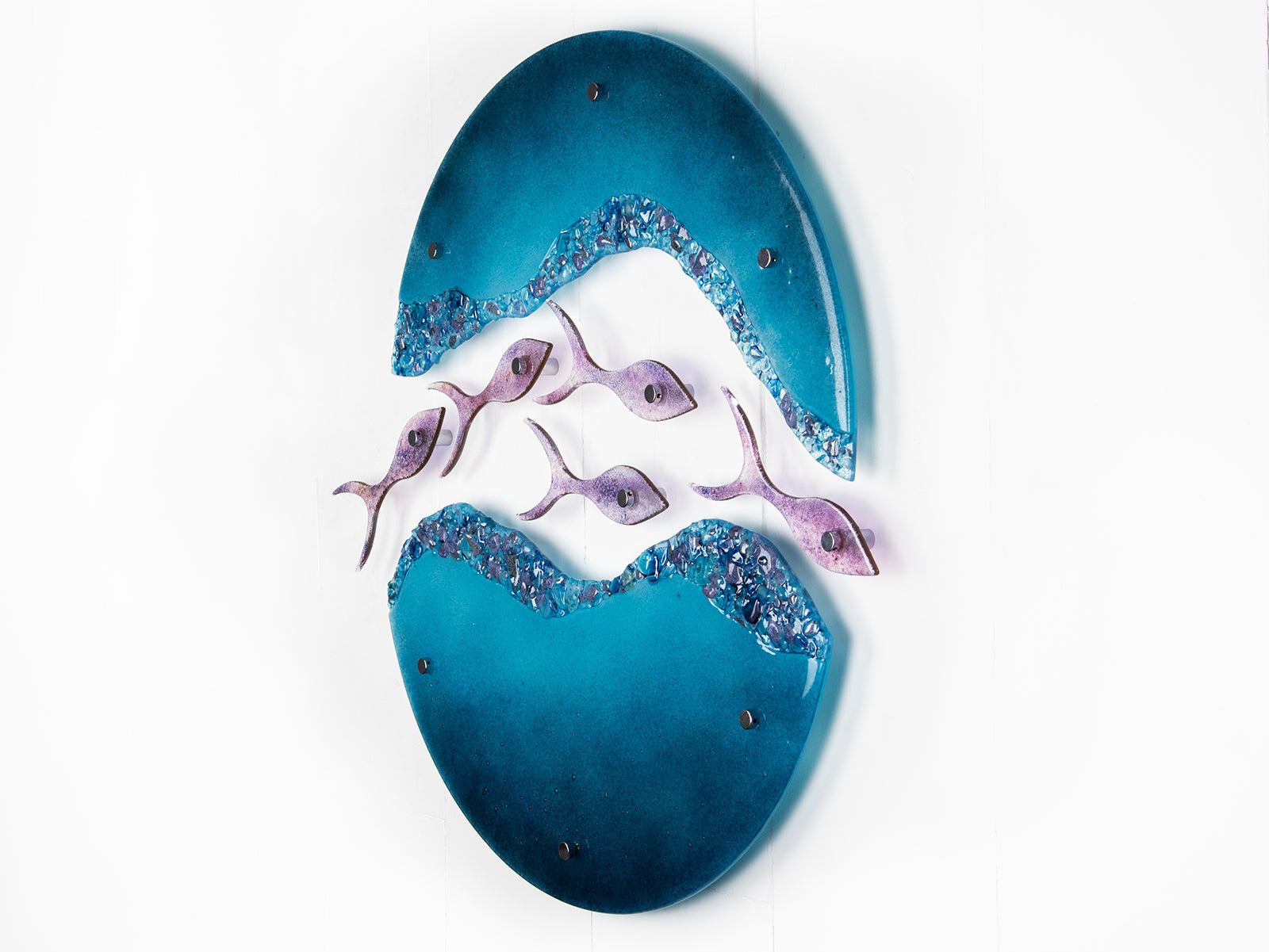Fused glass wall art display with shoal of fish and coastal blue colours. 