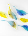 Fused glass leaf wall art display in bright yellows and sky blues. 