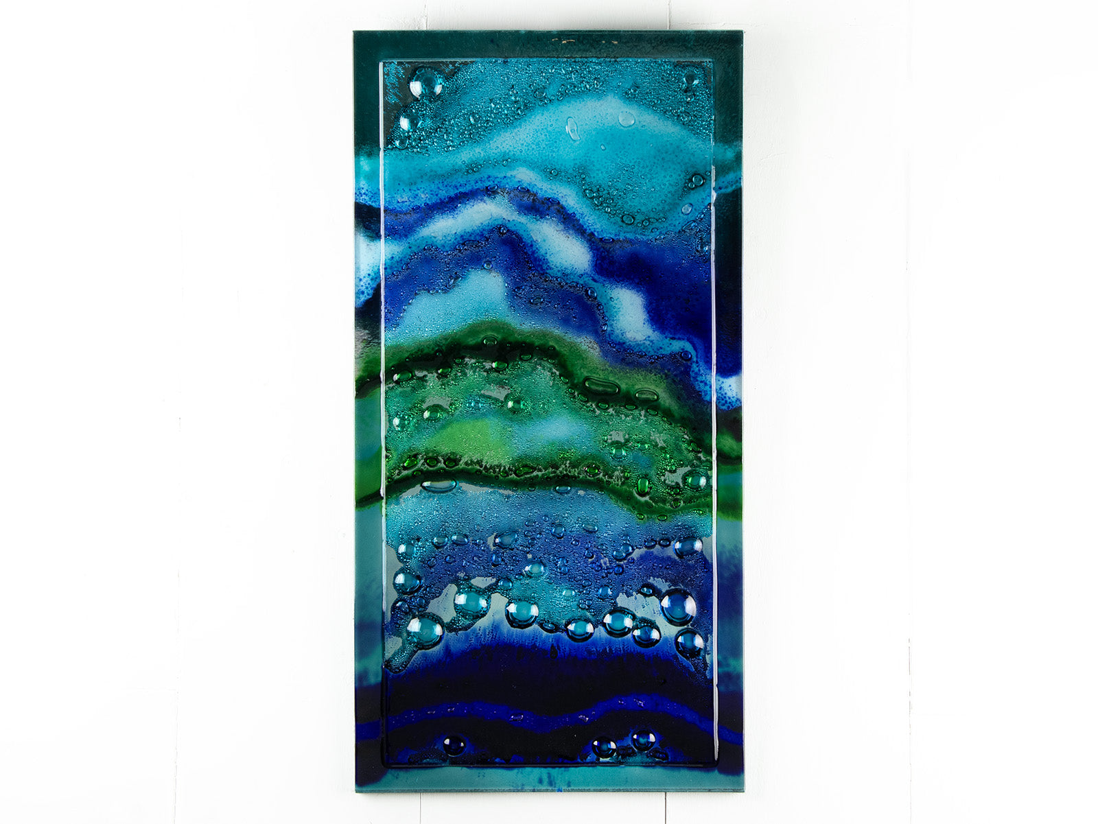 Abstract and bright fused glass wall panel, inspired by the ocean with coastal colours and bubbled detailing. 