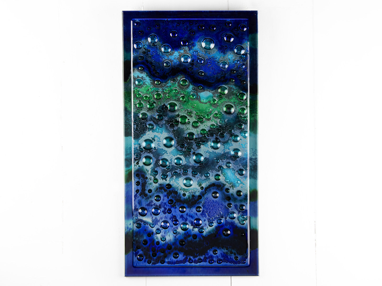 Abstract and bright fused glass wall panel, inspired by the ocean, with coastal colours and bubbled detail. 