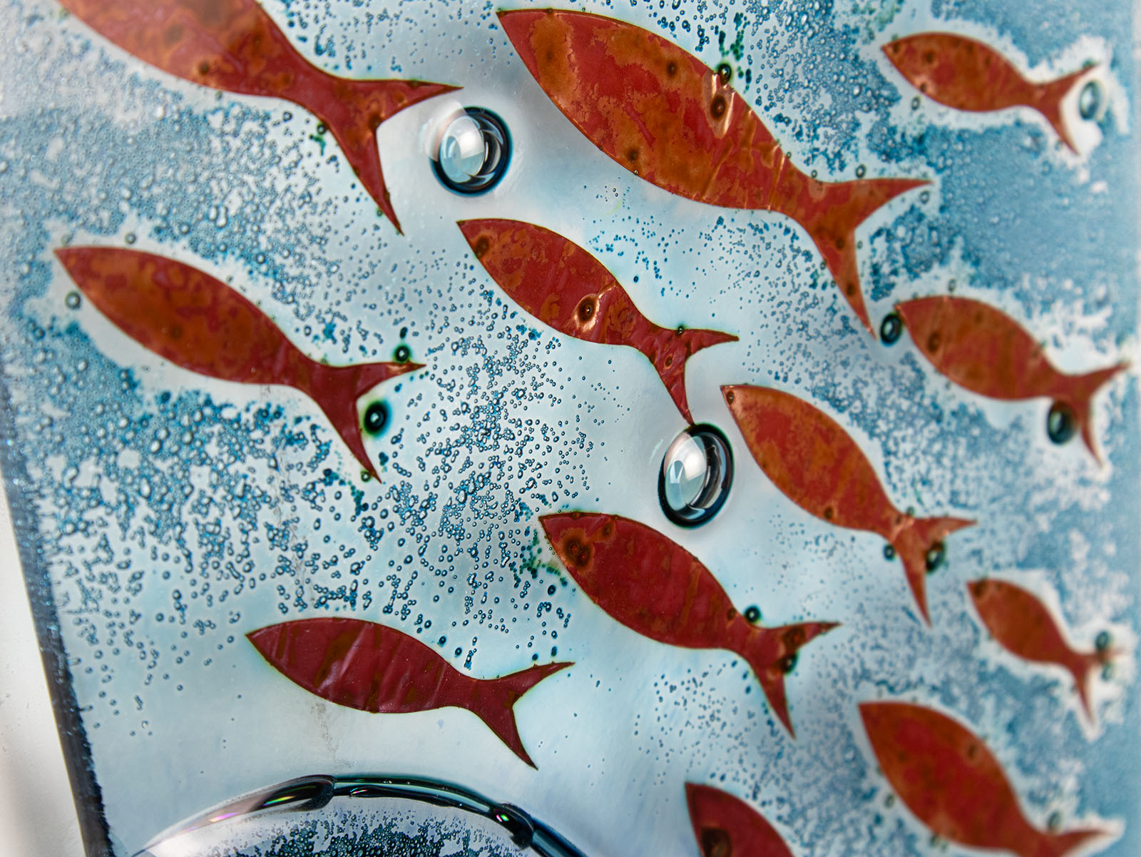 Copper fish details on fused glass wall panel, with marine blue colours. 