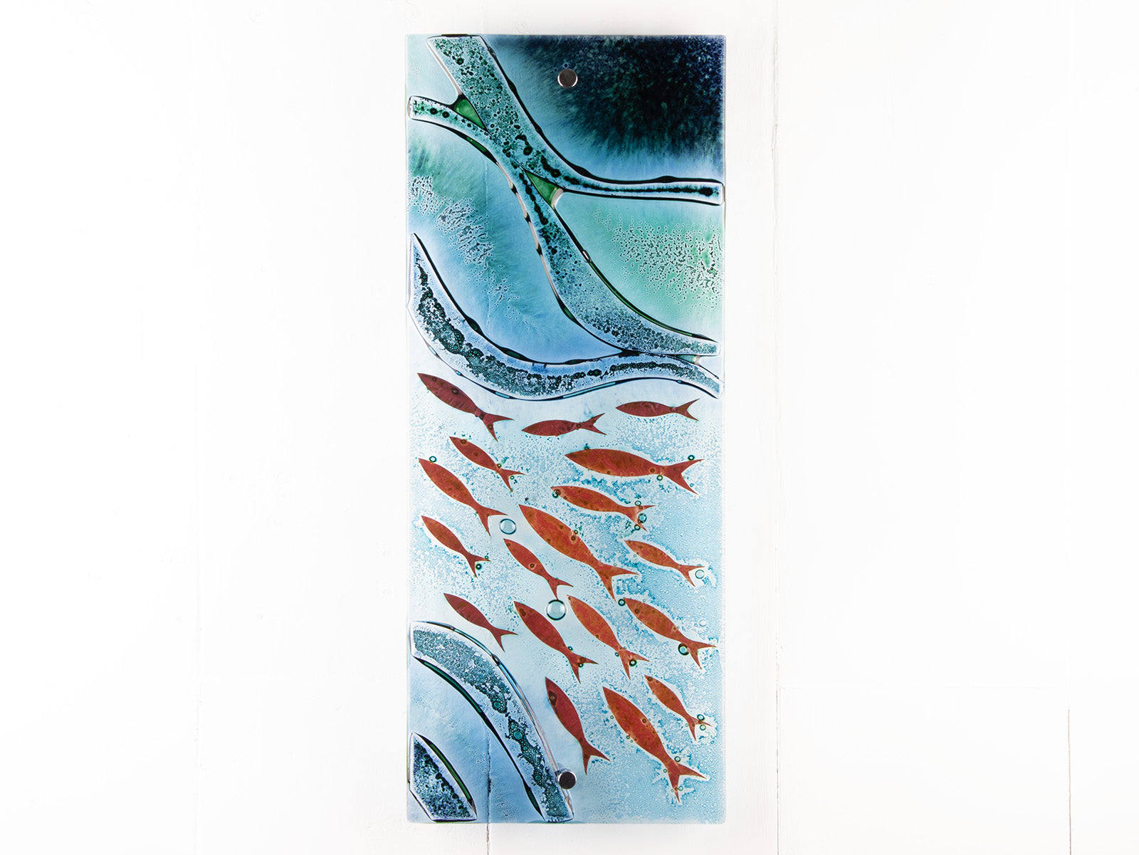 Fused glass wall panel featuring an ocean inspired design in marine blue hues and copper fish.