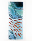 Fused glass wall panel featuring an ocean inspired design in marine blue hues and copper fish.