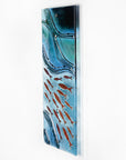 Fused glass wall panel featuring an ocean inspired design in marine blue hues and copper fish.