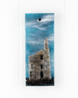 Small fused glass wall panel featuring a Cornish tin mine design, with a misty blue sky. 