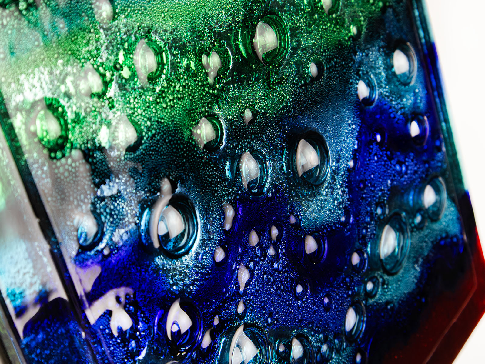 Bubbled detailing on abstract and bright fused glass wall panel, inspired by the atmosphere of the ocean, with coastal colours.